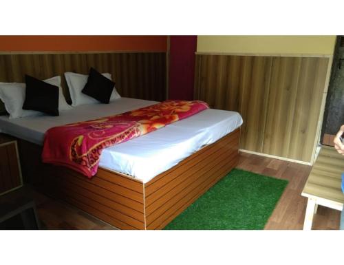 a bed in a room with a green rug at Pine Wood Resort, Barkot in Barkot