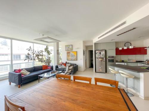 a kitchen and living room with a table and a couch at Spacious cosy & renovated flat in central Tel Aviv in Tel Aviv