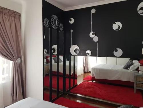a bedroom with black walls and a bed with a red rug at The Link on Bonsai in Kempton Park