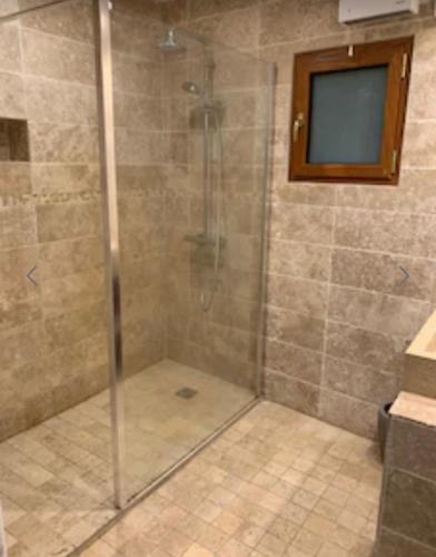 y baño con ducha y puerta de cristal. en Bergerie du 17ème siècle, piscine privative, en Toudon