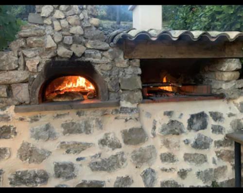 Un horno de piedra con fuego. en Bergerie du 17ème siècle, piscine privative, en Toudon