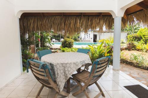 una mesa y sillas en un patio con piscina en El Flamboyan Apartments, en Las Terrenas