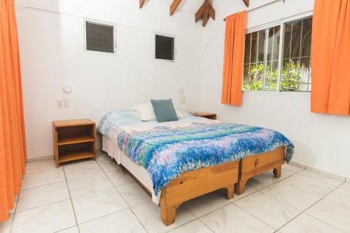 um quarto com uma cama e duas janelas em El Flamboyan Apartments em Las Terrenas