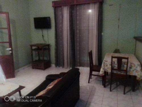 een woonkamer met een bank en een tafel bij Appartement F2 centre ville sécurisé in Diego Suarez