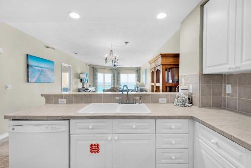 a kitchen with white cabinets and a sink at Emerald Isle Unit 704 in Pensacola Beach