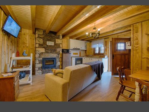 a living room with a couch and a stone fireplace at Casas Dos Barreiros in Melgaço