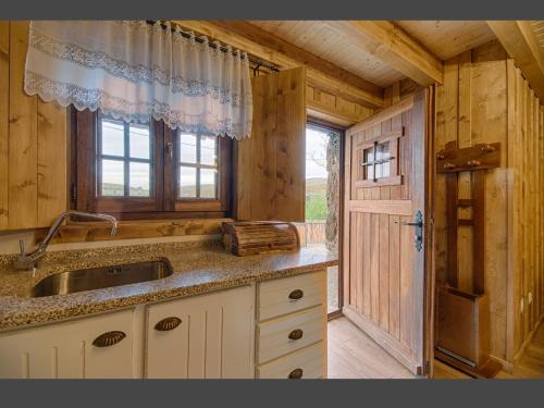uma cozinha com um lavatório e uma janela num camarote em Casas Dos Barreiros em Melgaço