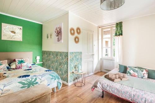 a bedroom with green walls and a bed and a couch at La Maison de la Colline in Vers