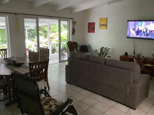 a living room with a couch and a tv at Bora Red Hibiscus Lodge in Bora Bora