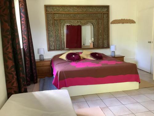 1 dormitorio con 1 cama con espejo grande en Bora Red Hibiscus Lodge en Bora Bora