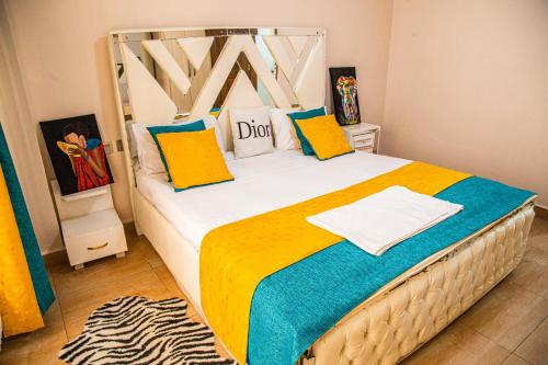 a bedroom with a bed with colorful sheets and pillows at The Fancy Luxurious 3 bedroom apartment in Nakuru