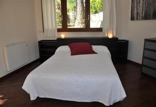 Un dormitorio con una cama con una almohada roja. en Villa besides the sea - 3 bedrooms, en Tarragona