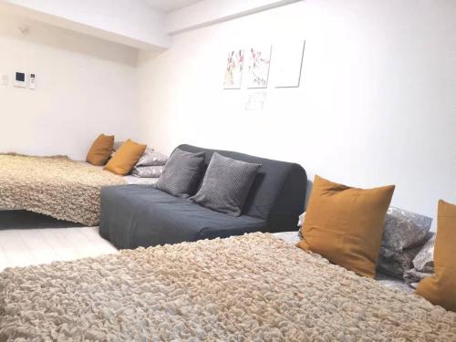 ein Wohnzimmer mit einem Sofa und einem Teppich in der Unterkunft GRHOUSE -Self Check in- Will send room number and password in Tokio