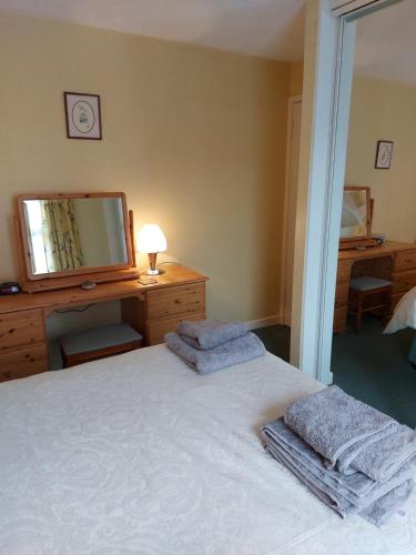 a bedroom with a bed and a dresser and a television at Oil Mill Lane Holiday Cottage in Berwick-Upon-Tweed