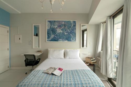 a bedroom with a bed with a book on it at KL Tower Makati Apartments by PH Staycation in Manila