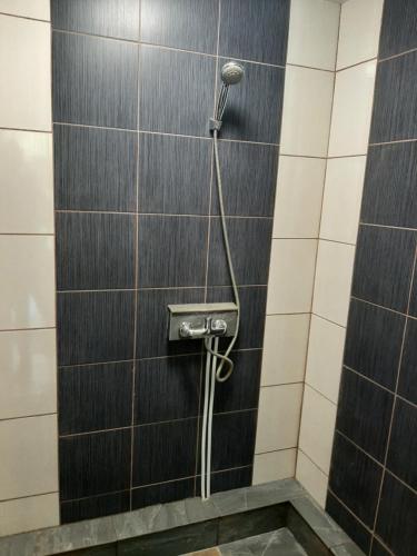 um chuveiro numa casa de banho com azulejos pretos e brancos em Mėgstantiems gaminti gamtoje 