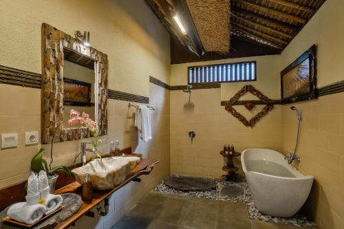 a bathroom with a tub and a sink at Teja Lokha Ubud Villa in Ubud