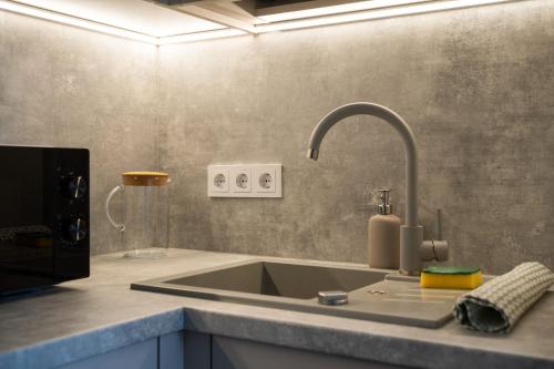 a kitchen counter with a sink with a faucet at Lazdyneliu Vingis in Vilnius