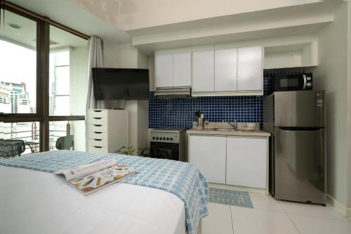 a kitchen with white cabinets and stainless steel appliances at KL Tower Makati Apartments by PH Staycation in Manila
