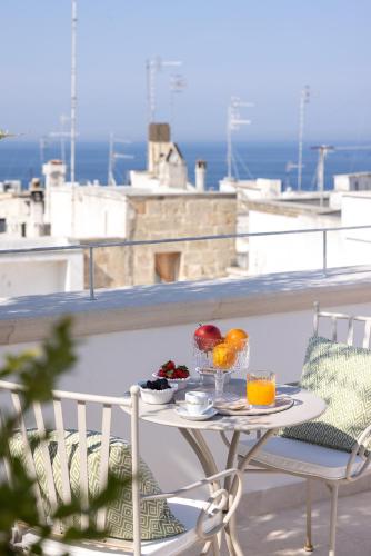 a table with fruit and drinks on a balcony at Dimore di Brando Vico Gelso in Polignano a Mare