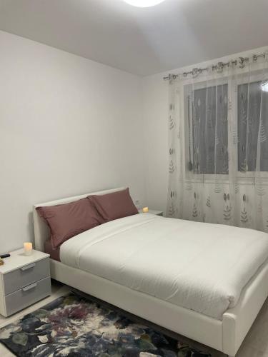 um quarto branco com uma cama e uma janela em Refugiul linistit em Giroc