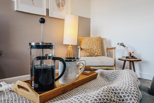 a coffee maker on a wooden tray on a table at Principality View Apartment Two, by Solace Stays in Cardiff
