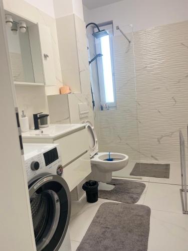 uma casa de banho com uma máquina de lavar roupa e um WC em Refugiul linistit em Giroc