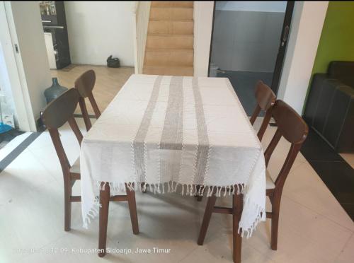 a table with two chairs and a white table cloth on it at Sidoarjo Homestay 