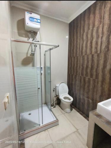 a bathroom with a shower and a toilet at Sidoarjo Homestay 