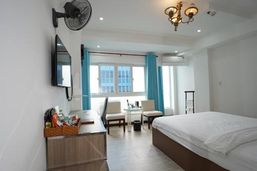 Schlafzimmer mit einem Bett, einem Schreibtisch und einem Tisch in der Unterkunft A25 Hotel - 14 Phó Đức Chính in Ho-Chi-Minh-Stadt