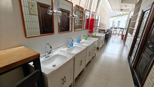 a bathroom with a row of sinks and mirrors at Slow Tune Space Backpacker Hostel in Jinghong