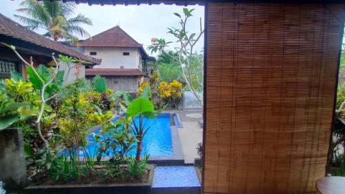 a view of a swimming pool from a house at Happy Inn 2 in Ubud