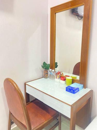 a white table with a mirror and a chair at Sun Tree Hotel in Kampong Kerayong
