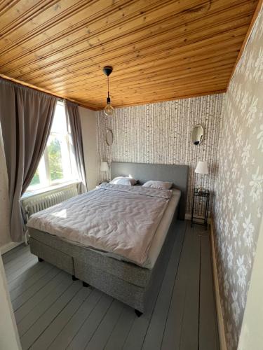 1 dormitorio con 1 cama grande y techo de madera en Arvika, Centralt en Arvika