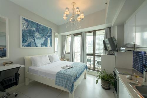 małą sypialnię z łóżkiem i kuchnią w obiekcie KL Tower Makati Apartments by PH Staycation w mieście Manila