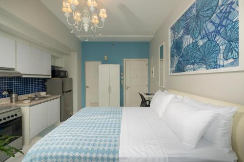 a bedroom with a white bed and a kitchen at KL Tower Makati Apartments by PH Staycation in Manila