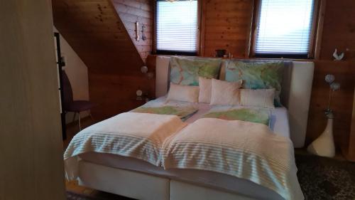 a bedroom with a large bed with white sheets and pillows at Ferienhaus Inselweg in Faak am See