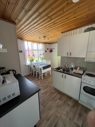 a kitchen with white cabinets and a dining room with a table at Arvika, Centralt in Arvika