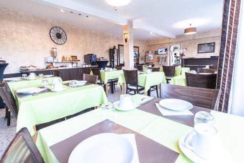 a dining room with green tables and chairs at Hôtel De La Plage in Le Chambon-sur-Lignon