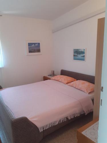 ein Schlafzimmer mit einem großen Bett mit orangefarbenen Kissen in der Unterkunft Apartman Čigir in Vir