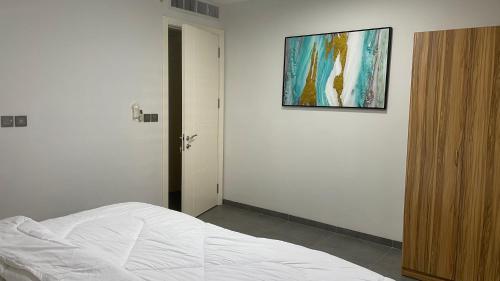 a bedroom with a bed and a painting on the wall at 3 bdrm Cityview Apt with Pool, Gym & Children Playground in Accra