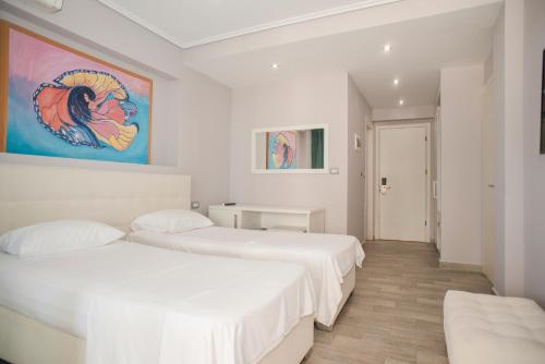 2 camas en una habitación con paredes blancas en Hotel Saranda International, en Sarandë