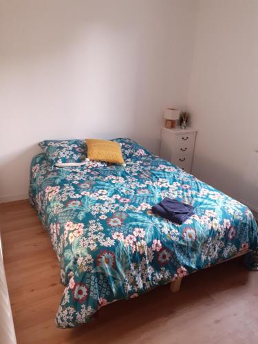 une chambre avec un lit avec un couvre-lit fleuri dans l'établissement Location maison 8 pers. avec spa - Morbihan, Theix, à Theix