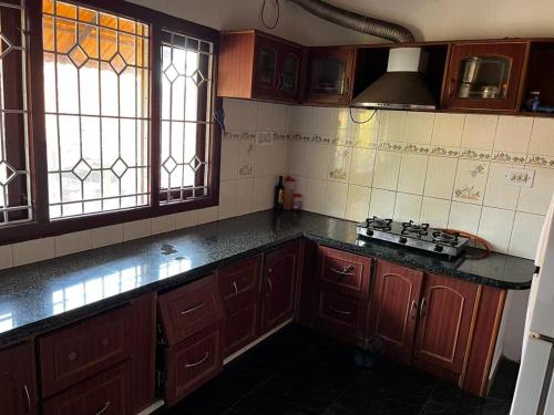 a kitchen with wooden cabinets and a counter top at La Paz Coorg homestay at Madikeri town in Madikeri