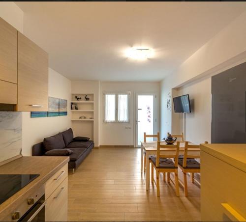 cocina y sala de estar con sofá y mesa en Miramare casa vacanze en Rímini