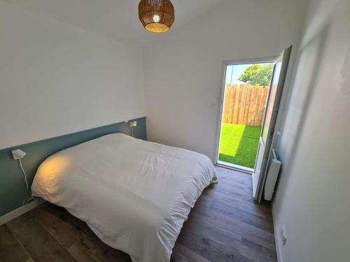 une chambre avec un lit et une porte coulissante en verre dans l'établissement Maison 4 personnes La nouvelle vague, à La Guérinière