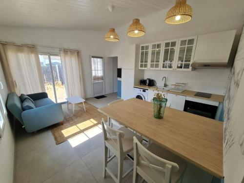 une cuisine et un salon avec une table et des chaises dans l'établissement Maison 4 personnes La nouvelle vague, à La Guérinière