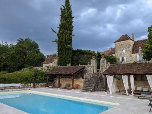 une piscine devant une maison avec un bâtiment dans l'établissement Les Pierres Lotoises- le cottage, à Reilhaguet