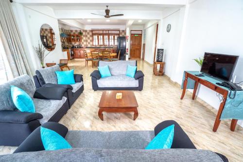 a living room with couches and a flat screen tv at La Belle Residence Self Catering Accommodation in Beau Vallon