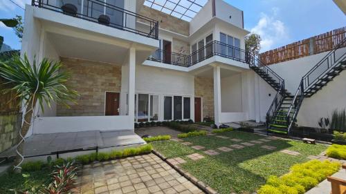 a house with a spiral staircase in a yard at Cahaya 1 Guest House in Songgoriti